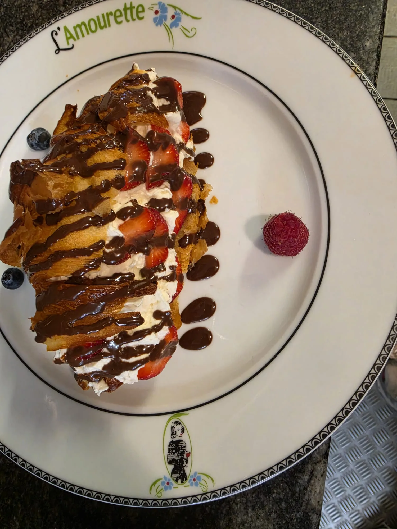 Dessert feuilleté garni de crème, de fraises et de chocolat servi à L’Amourette