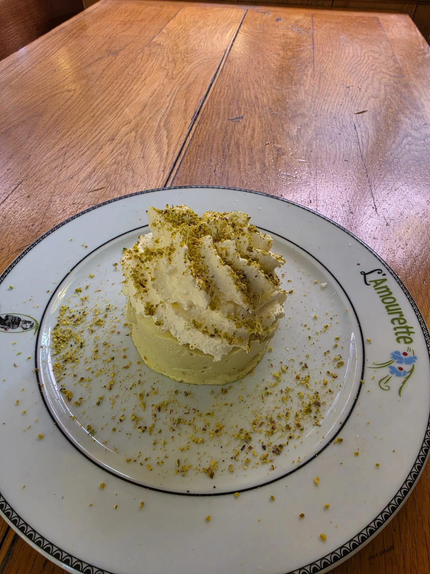 Dessert crémeux parsemé d’éclats de pistache servi à L’Amourette