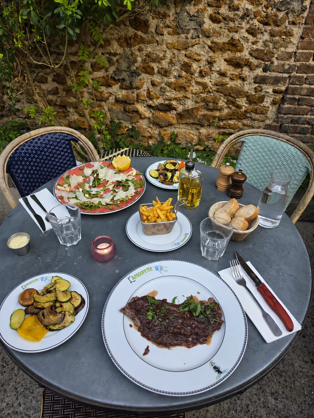 Table dressée avec plusieurs plats sur la terrasse de L’Amourette à Montreuil
